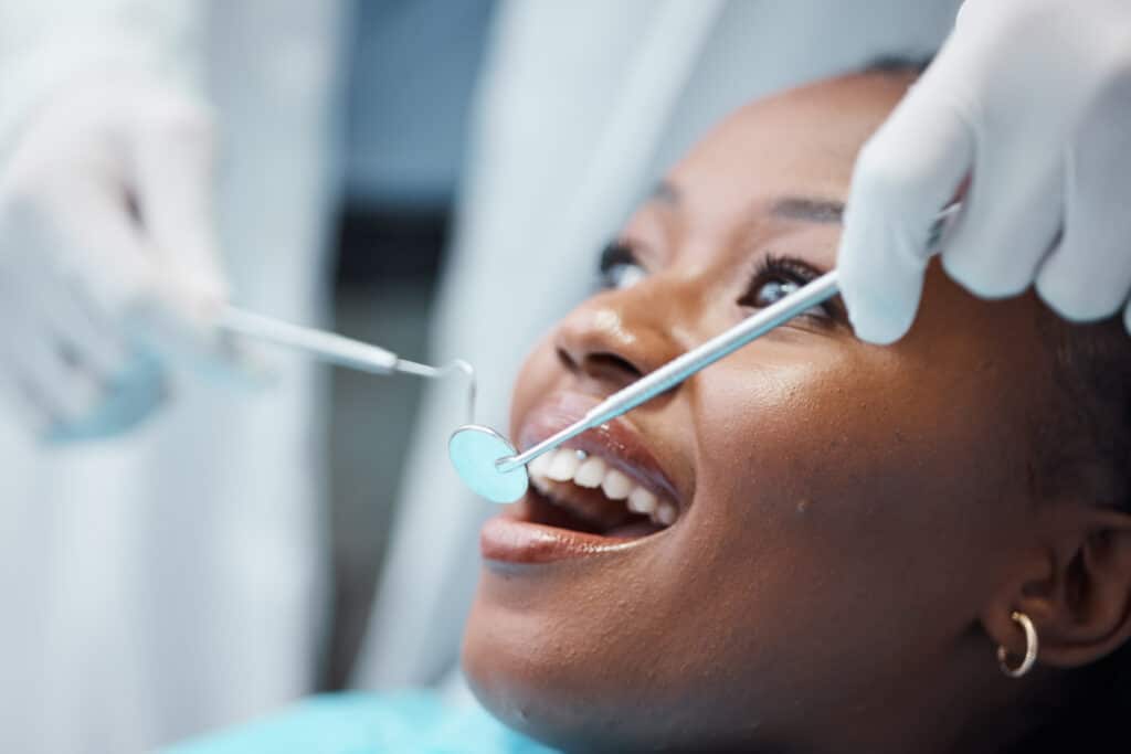 Dentist examining a patients teeth with a dental mirror