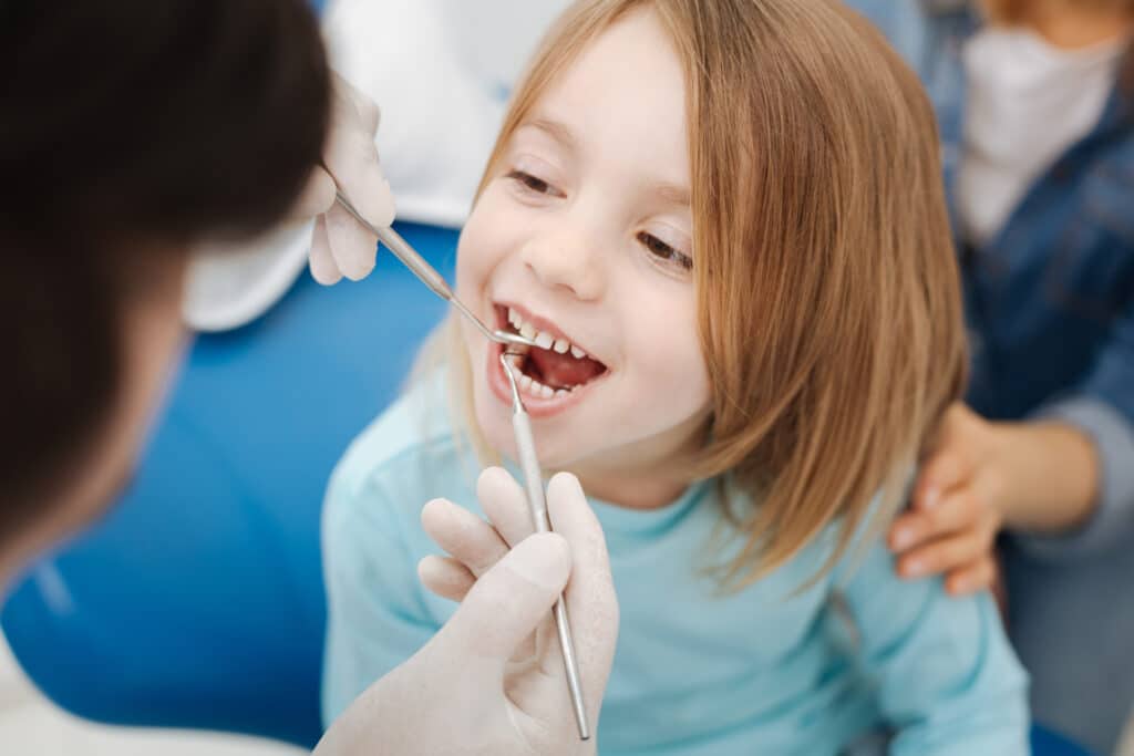Detnist performing a detnal exam on a child