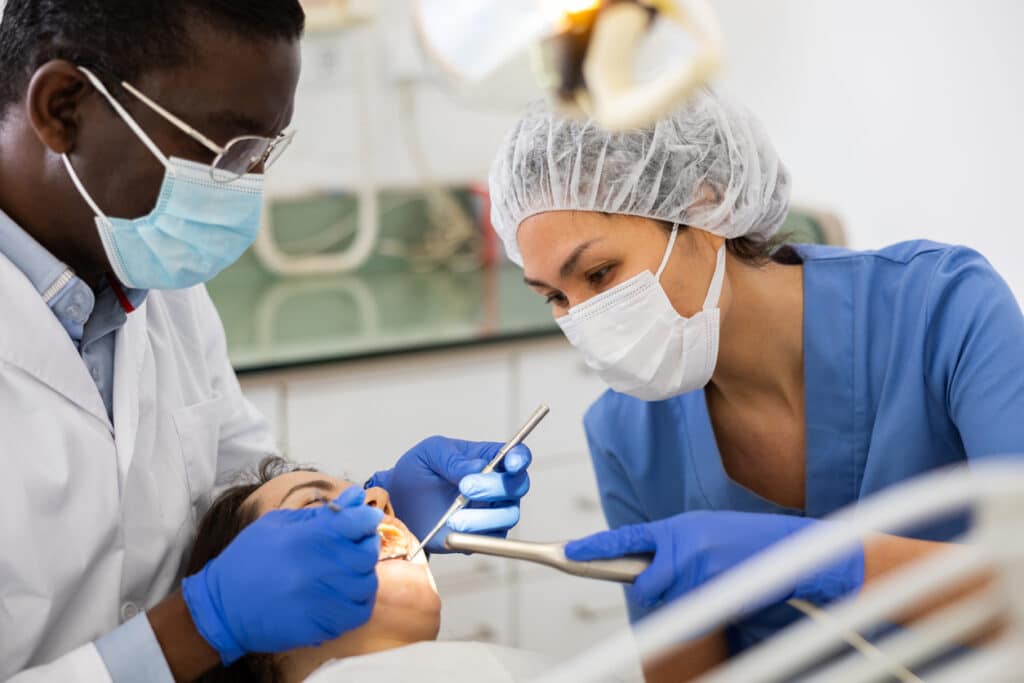 Dental hygienist assiting the dentist