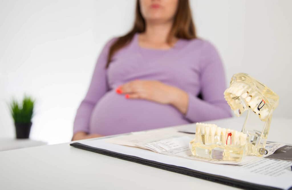 Dentists discussing prenatal dental care with a pregnant mother
