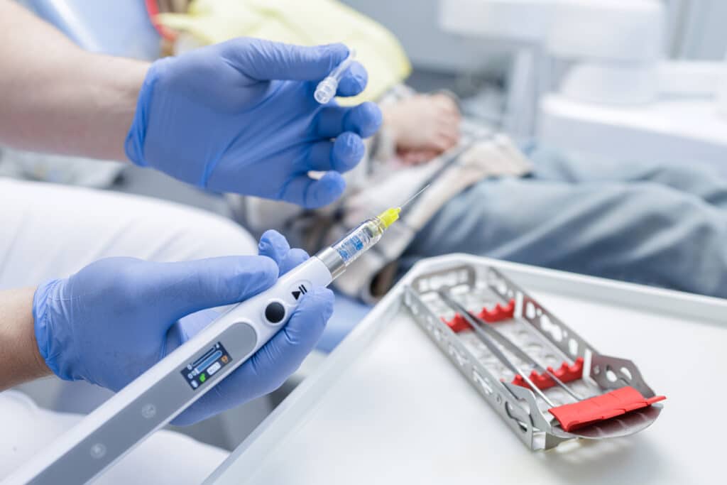 dentist displaying a needle with local anesthesia